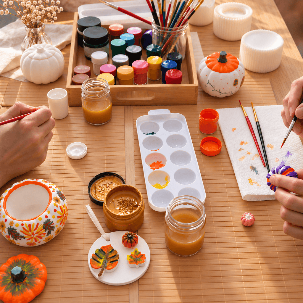 Atelier creativ MYGRACE de pictură a figurinelor ceramice, cu pensule, culori și obiecte decorative pictate manual, într-o atmosferă relaxată de toamnă.
