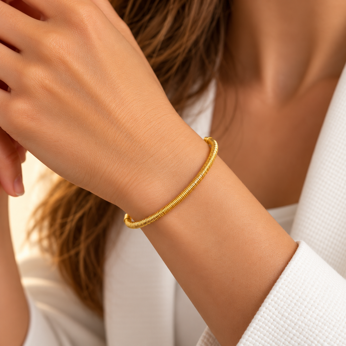 Brățară aurie din inox, bangle, reglabilă, pe mâna unui manechin.
